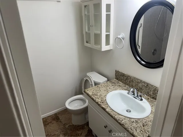 a bathroom with a granite countertop sink and a mirror