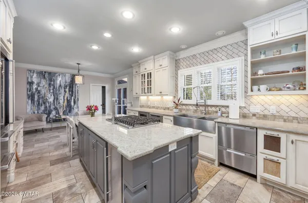 a kitchen with kitchen island granite countertop a sink cabinets and refrigerator