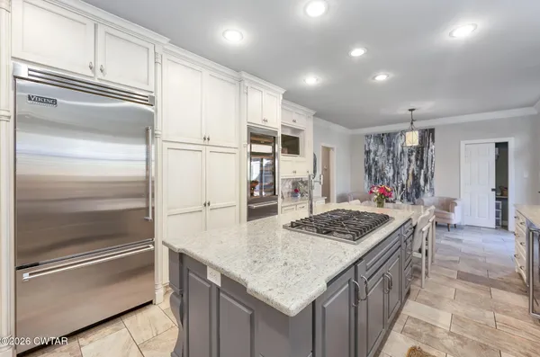 a large kitchen with stainless steel appliances granite countertop a sink and cabinets