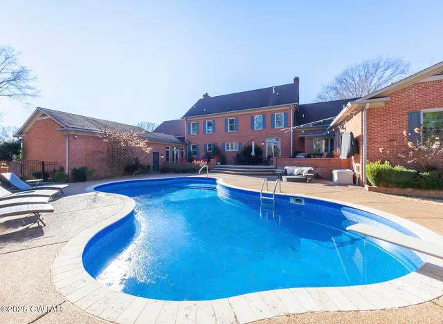 a swimming pool with outdoor seating and yard