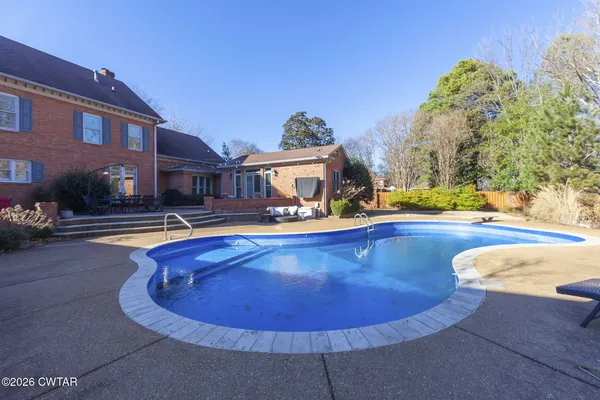 an aerial view of a swimming pool with outdoor seating and mountain view