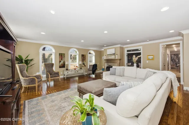 a living room with furniture kitchen view and large windows