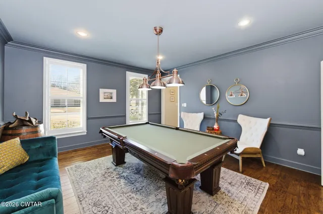 a room with pool table and windows