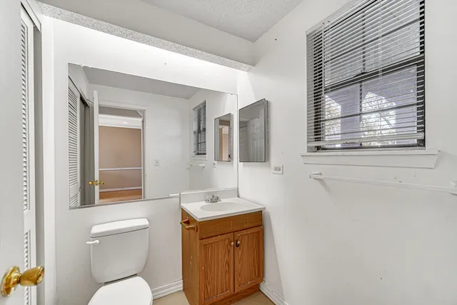 a bathroom with a toilet a sink and mirror