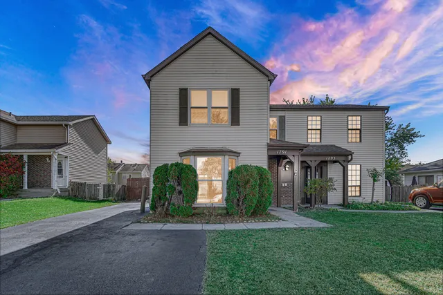 a front view of a house with a garden and plants
