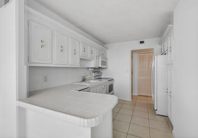 a kitchen with white cabinets stainless steel appliances and sink
