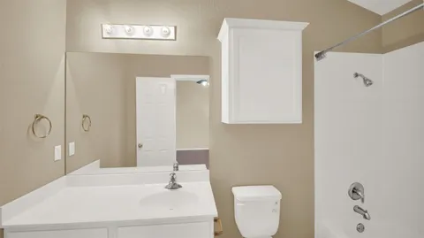 a bathroom with a sink a toilet and mirror