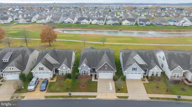 an aerial view of residential houses with outdoor space and ocean view