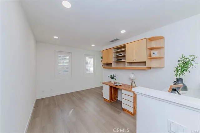 a view of a room with kitchen view and wooden floor