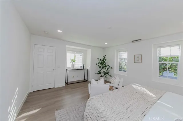 a bedroom with a large bed and potted plant