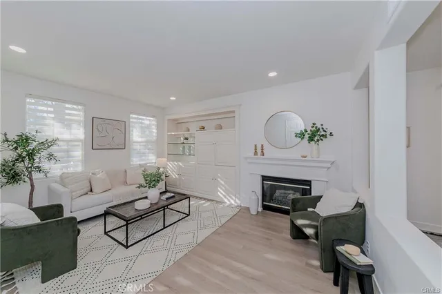 a living room with furniture a fireplace and a potted plant