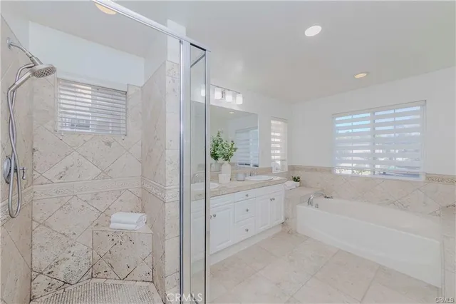 a spacious bathroom with a bathtub sink and mirror