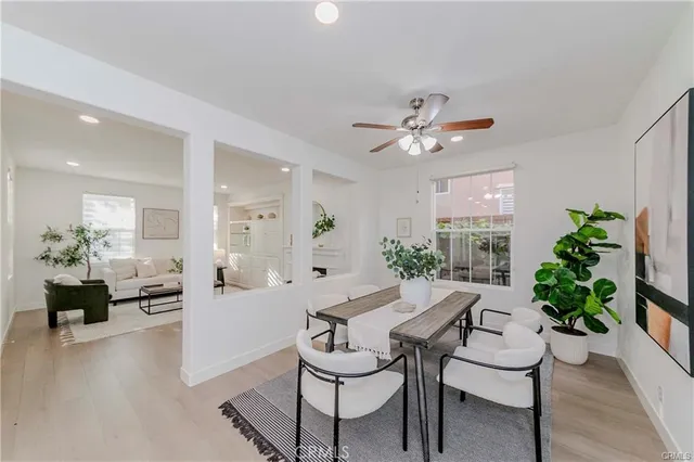 a dining room with furniture potted plants and a chandelier