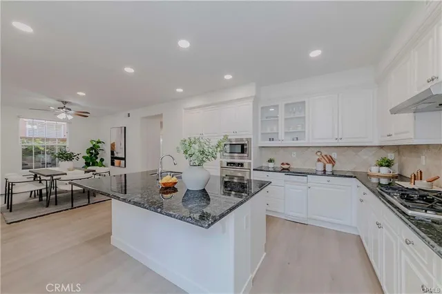 a kitchen with stainless steel appliances granite countertop sink stove and cabinets