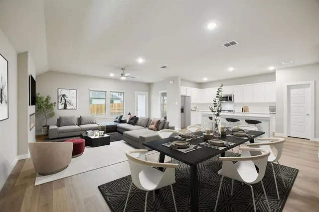 a living room with lots of furniture and view of kitchen
