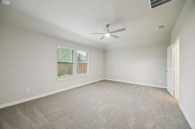 en empty room with windows and ceiling fan