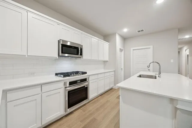 a kitchen with a sink stove and microwave