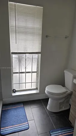 a bathroom with a toilet and a window