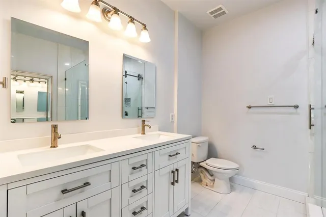 a bathroom with a sink a toilet and a mirror