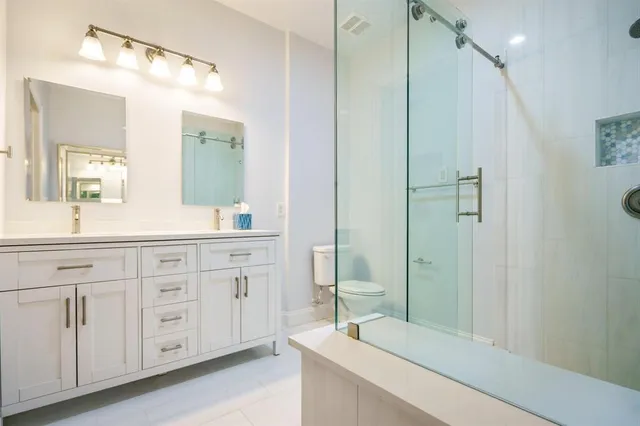 a bathroom with a double vanity sink mirror and shower
