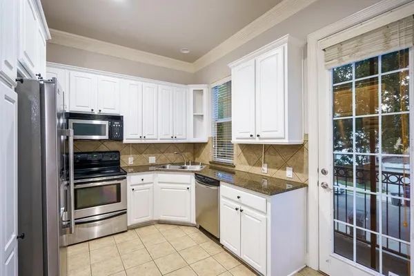 a kitchen with stainless steel appliances granite countertop a stove and a refrigerator