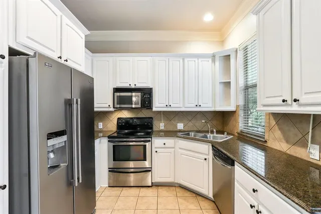 a kitchen with white cabinets and stainless steel appliances