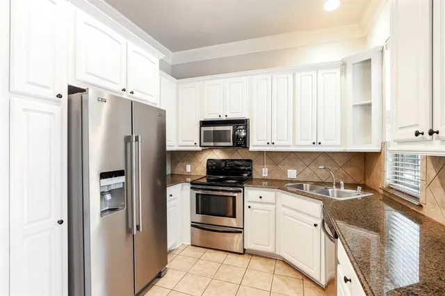 a kitchen with white cabinets and stainless steel appliances