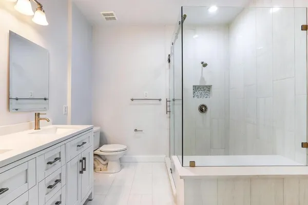a bathroom with a sink a toilet and shower