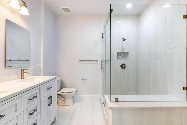 a bathroom with a sink a toilet and shower