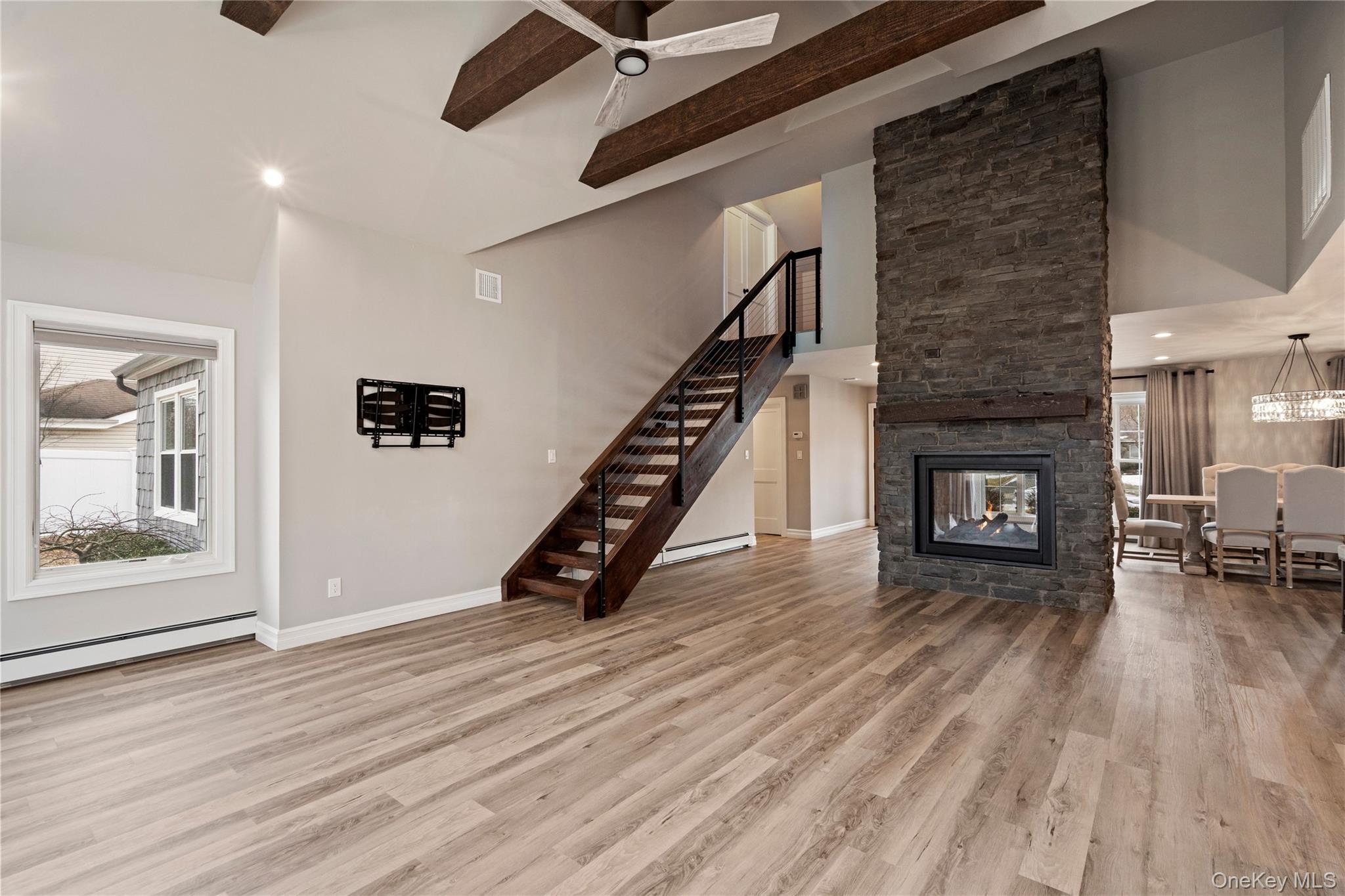 58 Timber Ridge Drive Commack, NY 11725 - Photo 16 of 34 Unfurnished living room featuring recessed lighting, light wood-style floors, a stone fireplace, stairs, and baseboard heating