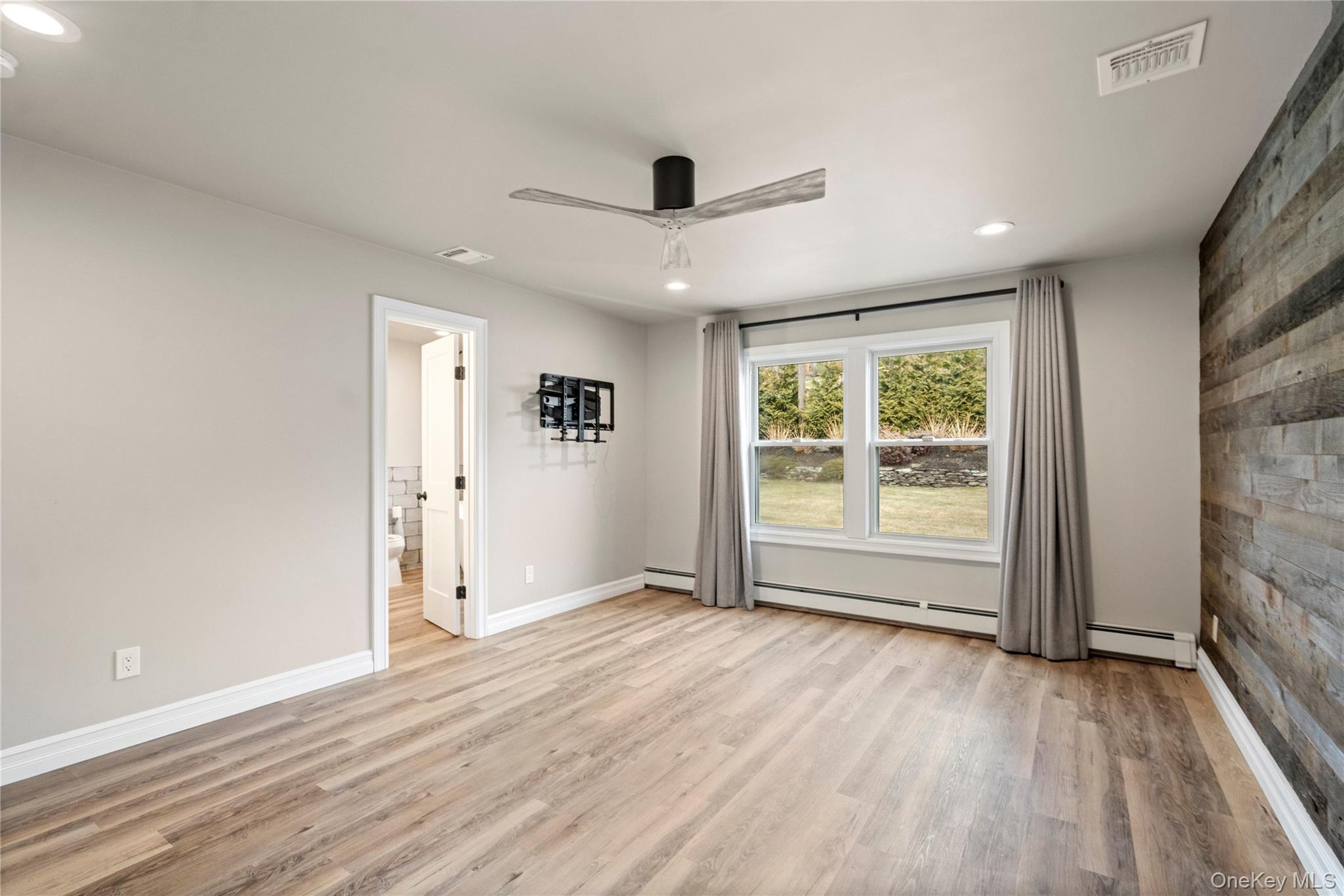 58 Timber Ridge Drive Commack, NY 11725 - Photo 23 of 34 Unfurnished room featuring ceiling fan, light wood finished floors, recessed lighting, and a baseboard radiator