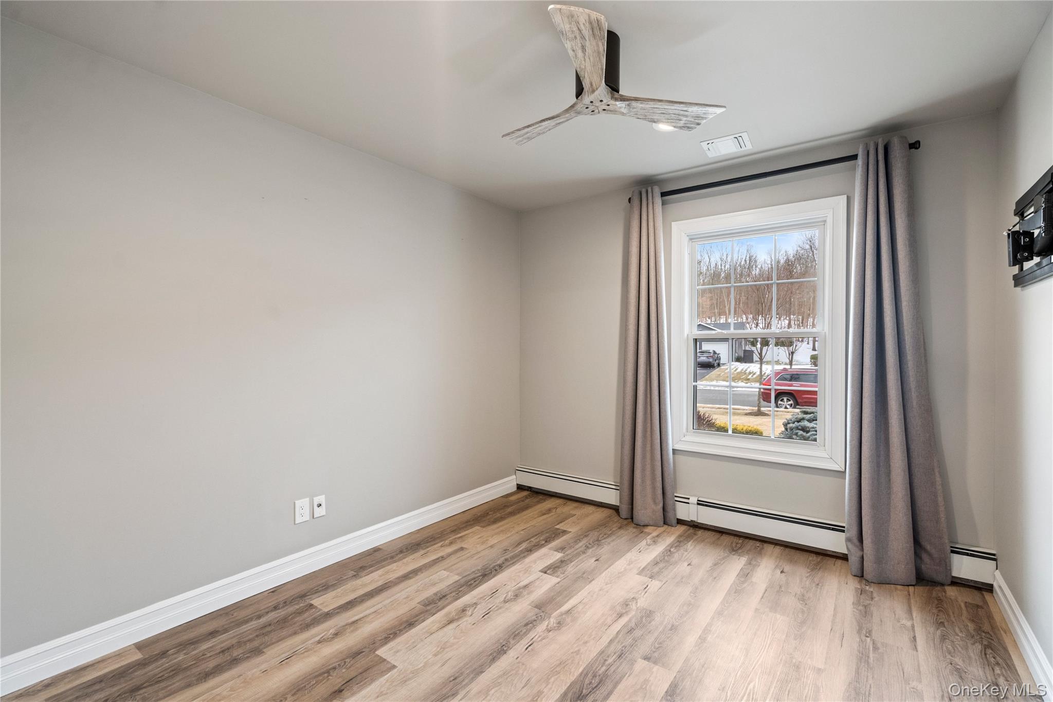 58 Timber Ridge Drive Commack, NY 11725 - Photo 24 of 34 Unfurnished room with light wood-type flooring, ceiling fan, and baseboard heating