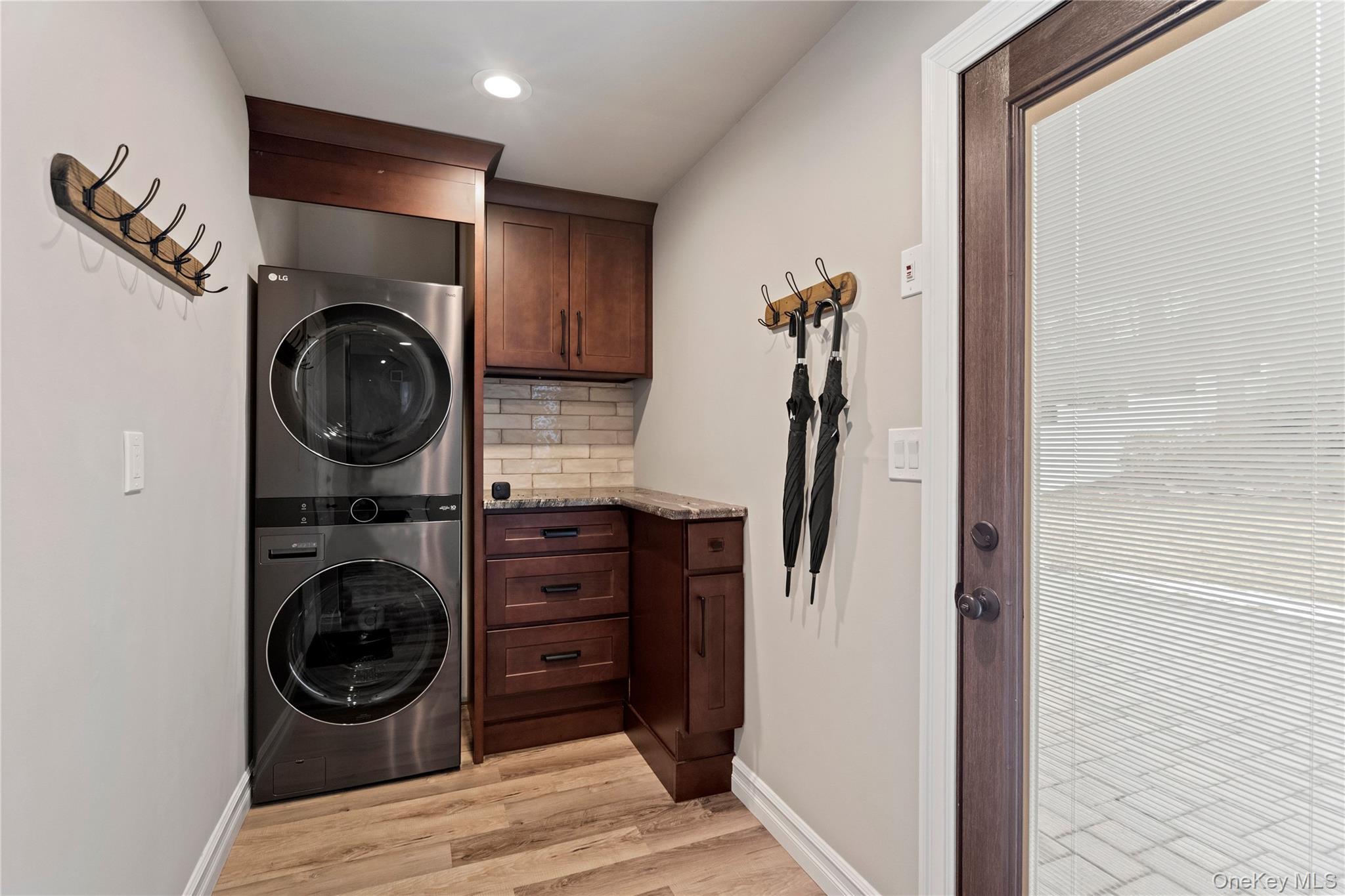 58 Timber Ridge Drive Commack, NY 11725 - Photo 29 of 34 Laundry room with light wood-style floors, stacked washer and clothes dryer, cabinet space, and recessed lighting