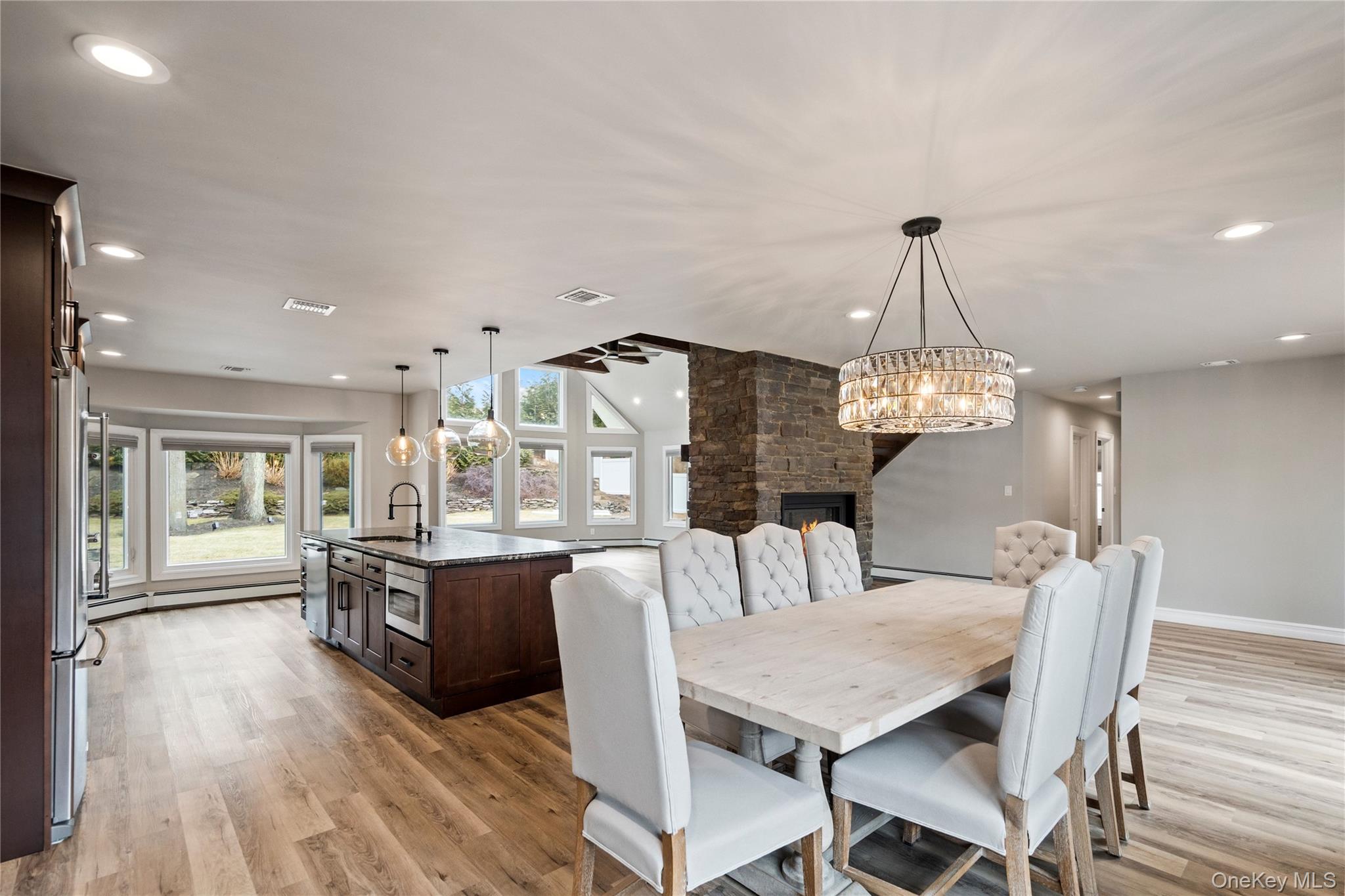58 Timber Ridge Drive Commack, NY 11725 - Photo 6 of 34 Dining area featuring a stone fireplace, recessed lighting, light wood-style floors, and a chandelier