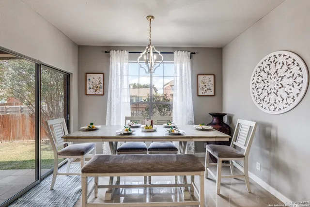 a dining room with furniture a chandelier and wooden floor