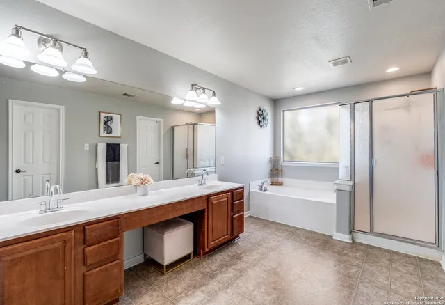 a spacious bathroom with a tub double sink and mirror