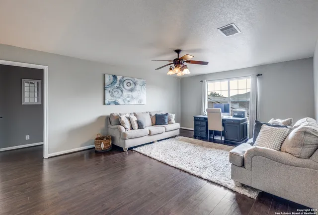 a living room with furniture and wooden floor