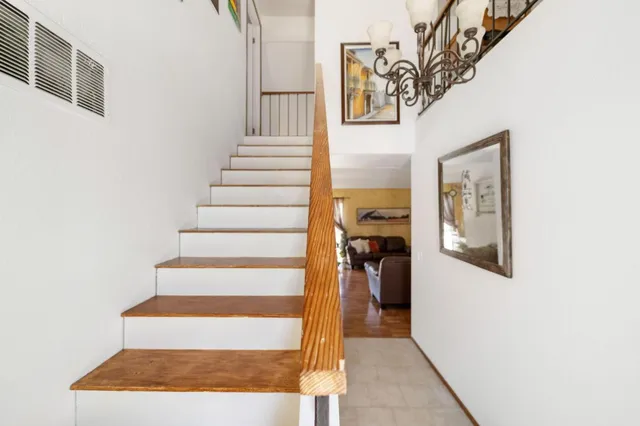 a view of staircase with white walls and a painting on the wall