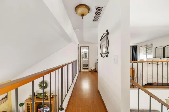 a view of a hallway with wooden floor and staircase