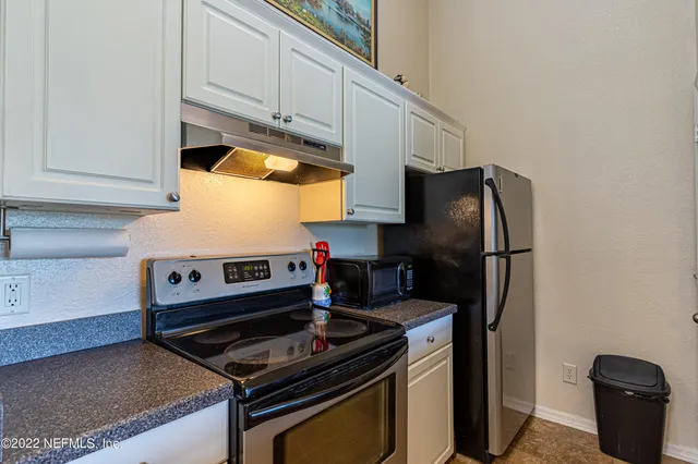 a kitchen with stainless steel appliances granite countertop a stove and a refrigerator