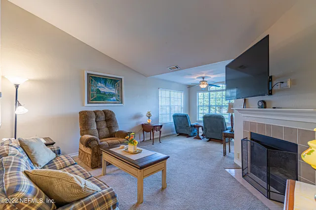 a living room with furniture a fireplace and a window