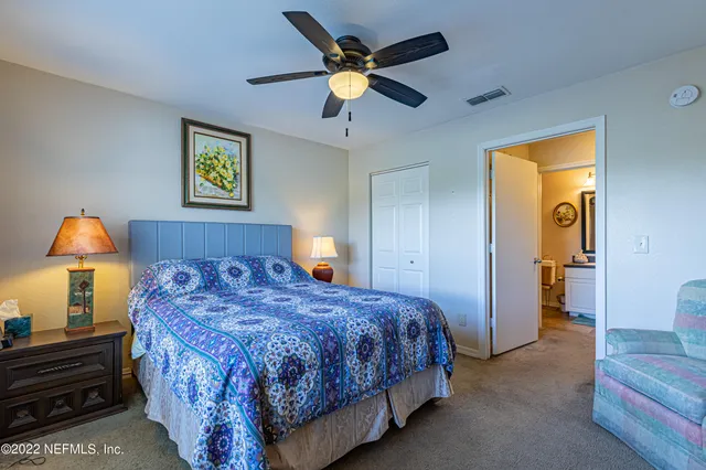 a bedroom with a bed and a lamp on dresser
