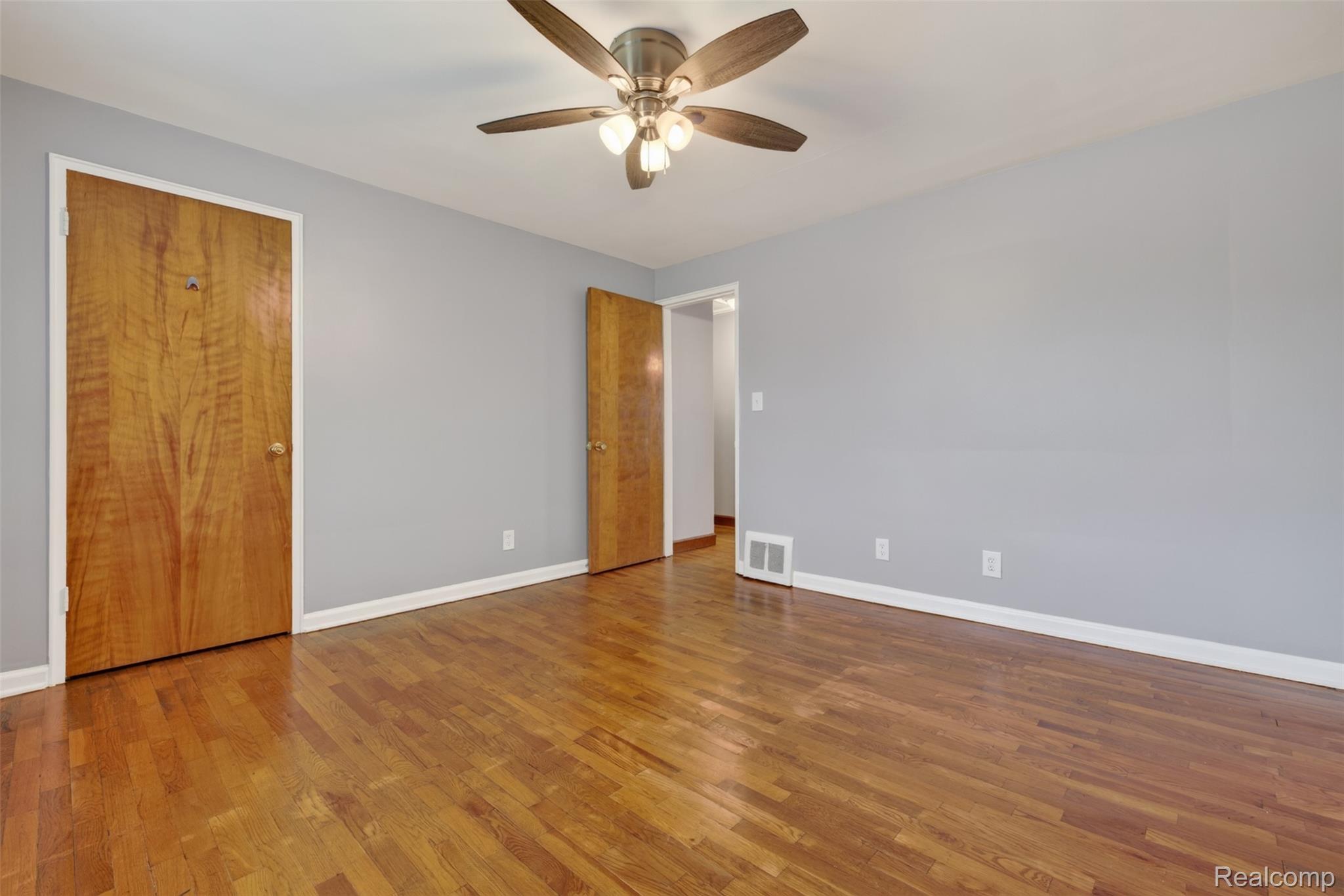 316 Sheffield Avenue Flint, MI 48503 - Photo 21 of 37 Hardwood flooring, light gray wall paint, and a ceiling fan with integrated lighting