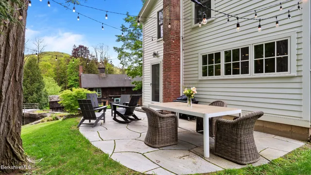 a view of a patio with table and chairs with plants and garden