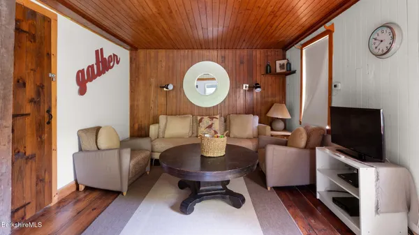 a living room with furniture a flat screen tv and a large window