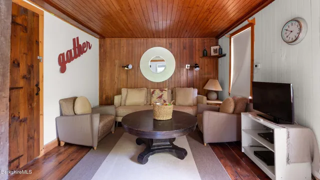 a living room with furniture a flat screen tv and a large window