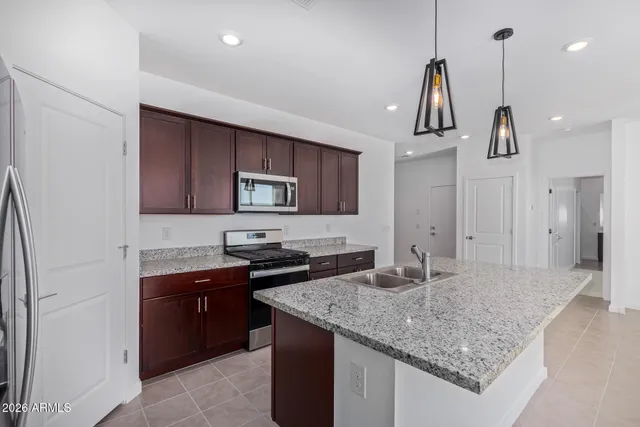a kitchen with stainless steel appliances granite countertop a sink and a refrigerator