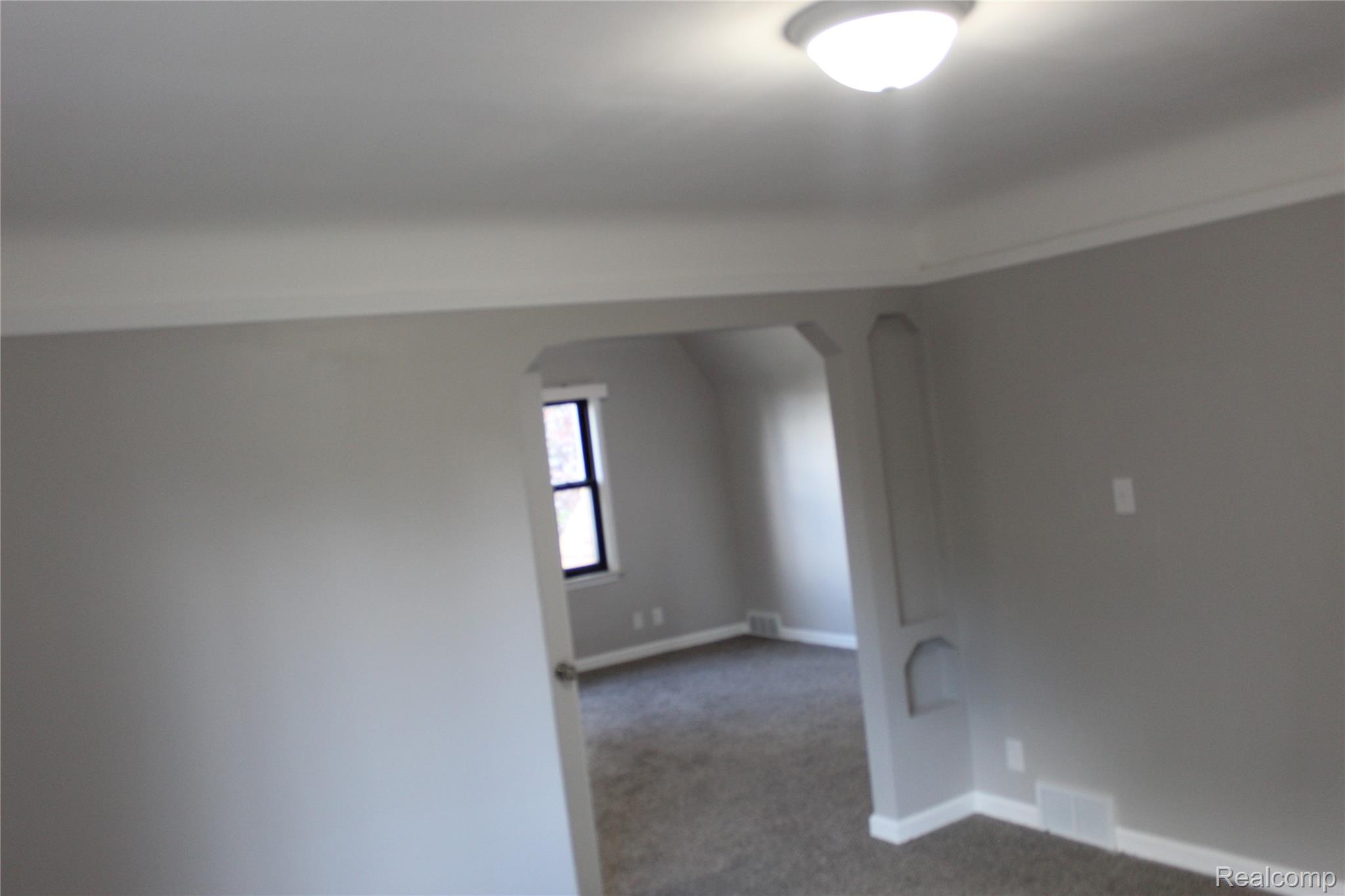 5543 Balfour Road Detroit, MI 48224 - Photo 48 of 54 Room featuring light gray walls, white trim, recessed archways, and a ceiling-mounted light fixture