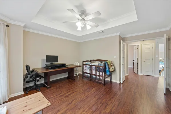a bedroom with a bed and wooden floor