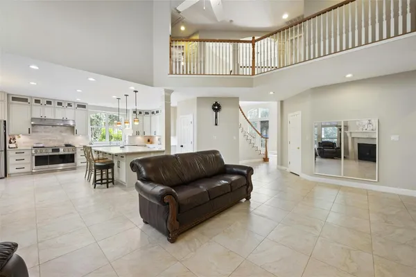 a living room with furniture and a open kitchen view